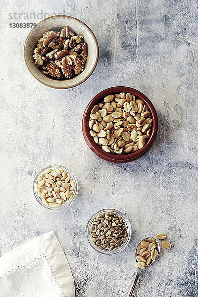 Hochwinkelansicht verschiedener Nüsse in Schalen auf dem Tisch