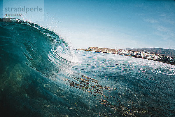 Szenische Ansicht des Wellenplätscherns im Meer auf den Kanarischen Inseln vor blauem Himmel