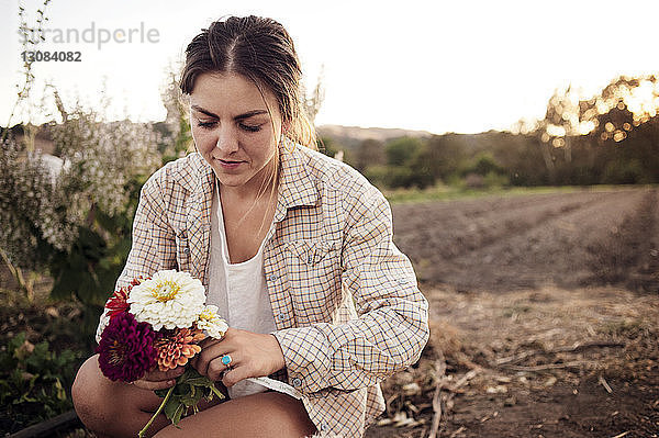 Bäuerin hält schöne Blumen auf dem Feld