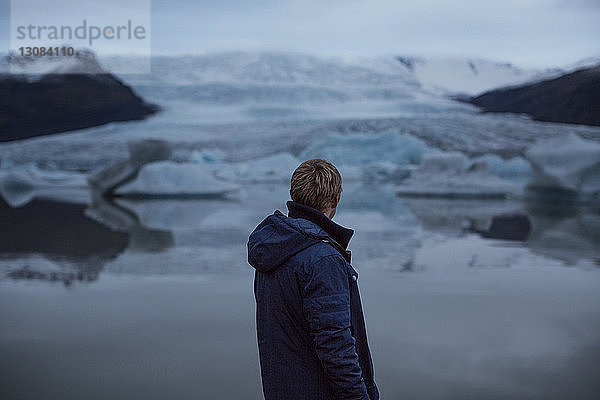 Rückansicht eines Menschen  der auf Gletscher schaut