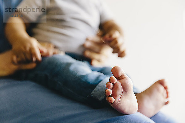 Mittelteil einer Ärztin mit einem kleinen Jungen vor weissem Hintergrund sitzend