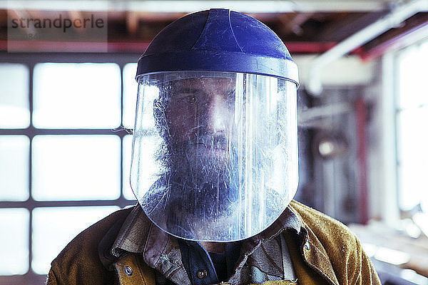 Porträt eines Arbeiters mit Schutzmaske in einer Fabrik