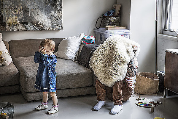 Vater und Tochter spielen zu Hause Verstecken