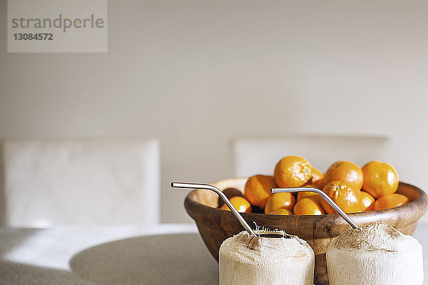 Clementinen in Schale mit Kokosnüssen auf dem heimischen Tisch