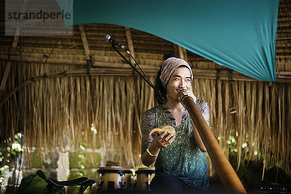 Fröhlicher Musiker spielt Alphorn während der Veranstaltung