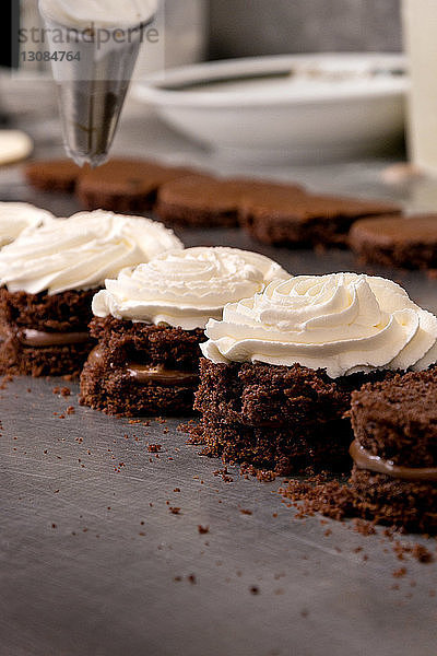 Nahaufnahme von Schlagsahne-Schoko-Biskuitkuchen an der Küchentheke