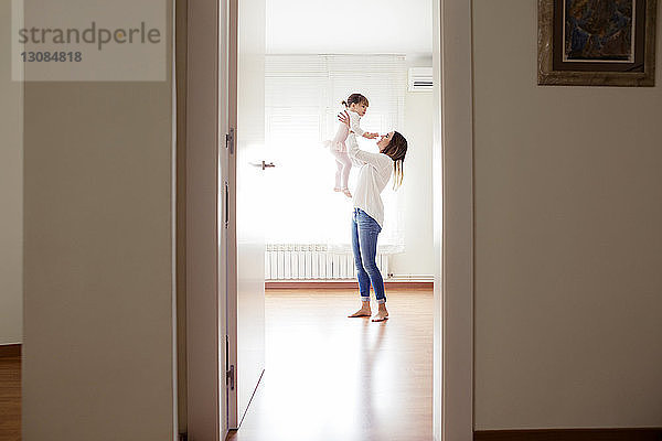 Seitenansicht einer Mutter  die ein Mädchen aussucht  das zu Hause ein Tutu trägt