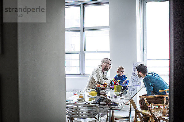 Väter sehen Tochter beim Zeichnen im Wohnzimmer an