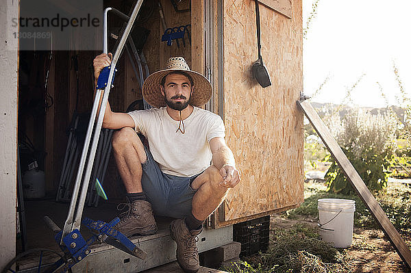 Porträt eines selbstbewussten männlichen Landwirts  der in einer Kabine auf dem Feld sitzt