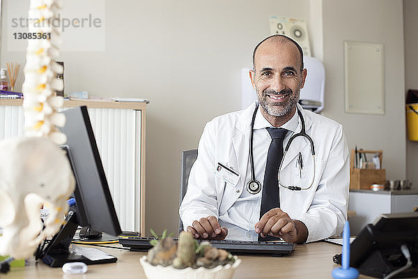 Porträt eines Arztes  der im Krankenhaus am Tisch arbeitet