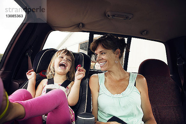 Fröhliche Großmutter und Enkelin sitzen im Auto