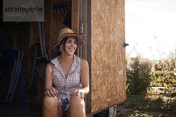 Glückliche Bäuerin sitzt in Hütte auf dem Feld