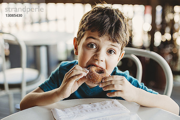 Porträt eines Jungen beim Donut-Essen im Restaurant