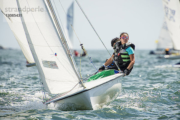 Freunde segeln während einer Regatta auf einem Segelboot