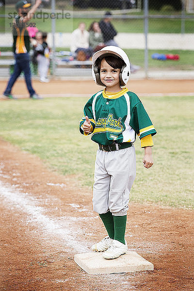 Porträt eines lächelnden Jungen mit Daumen nach oben auf dem Baseballfeld