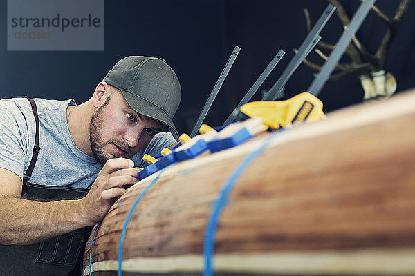 Zimmermann  der auf einem Holzboot arbeitet