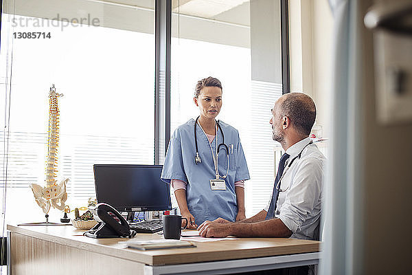 Arzt im Gespräch mit einem Mitarbeiter im Krankenhaus