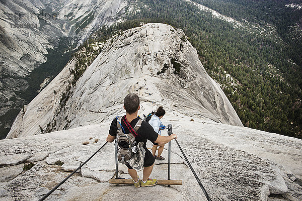 Wanderer  die von einer Felsformation im Yosemite-Nationalpark herunterkommen