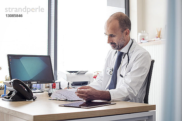 Arzt  der im Krankenhaus am Tisch sitzt