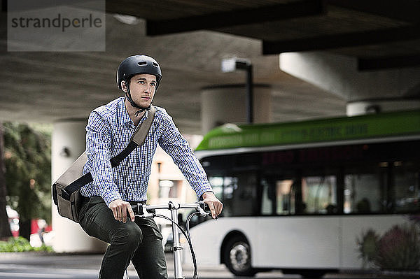 Geschäftsmann mit Fahrrad auf der Straße in der Stadt