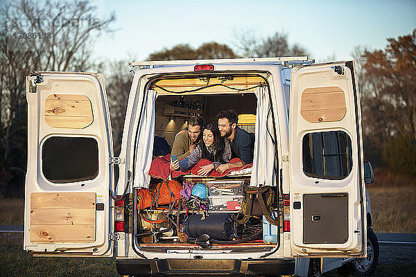 Freunde unterhalten sich im Bett liegend im Wohnmobil