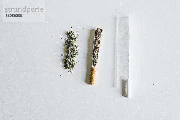 Draufsicht auf Marihuana-Joints und Zigarette mit Papier auf dem Tisch