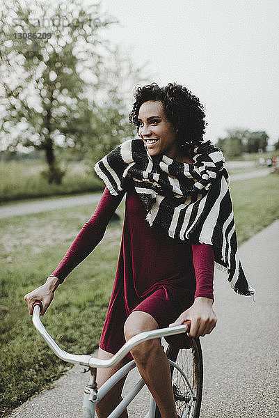 Lächelnde Frau beim Fahrradfahren im Park