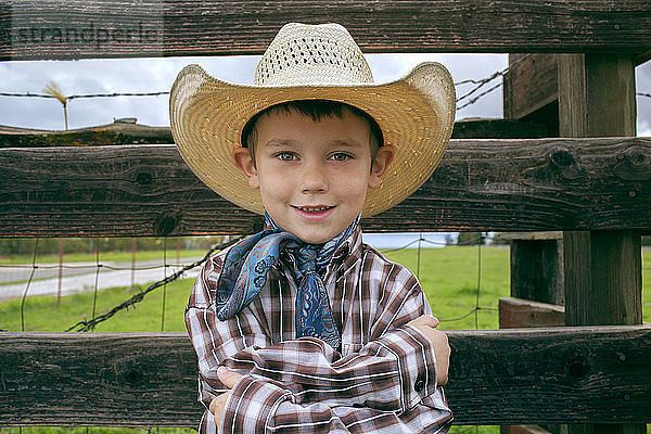 Porträt eines glücklichen Jungen mit Cowboyhut auf dem Feld