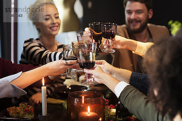 Glückliche Freunde stoßen bei der Weihnachtsfeier auf Wein an