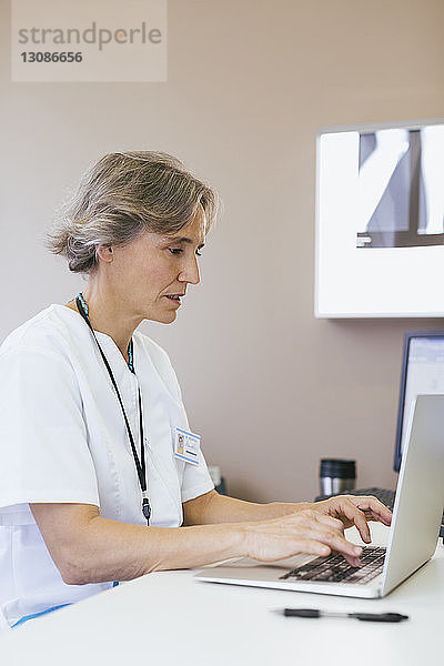 Leitende Ärztin  die im Krankenhaus am Laptop arbeitet