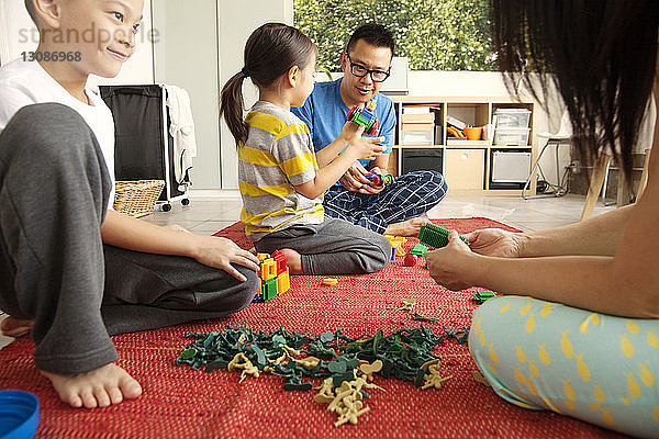 Familie spielt zu Hause mit Spielzeug auf dem Boden