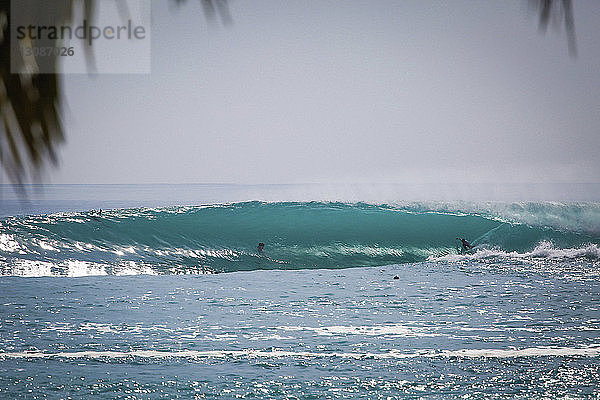 Menschen surfen im Meer auf der Insel Mentawai bei klarem Himmel