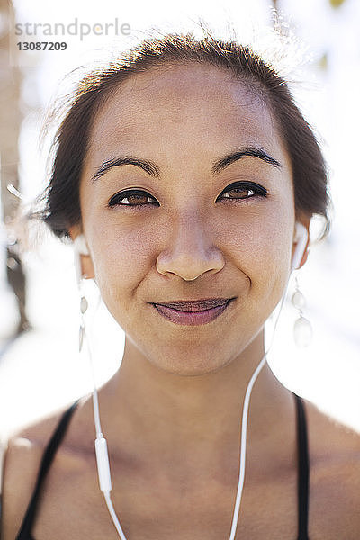 Nahaufnahme-Porträt einer lächelnden jungen Frau mit Kopfhörern