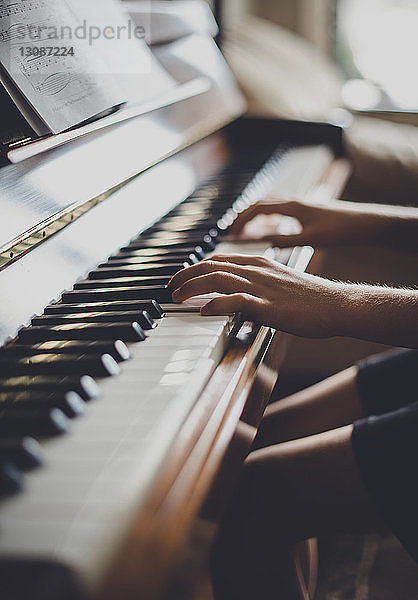 Ausgeschnittenes Bild eines Jungen  der zu Hause Klavier spielt