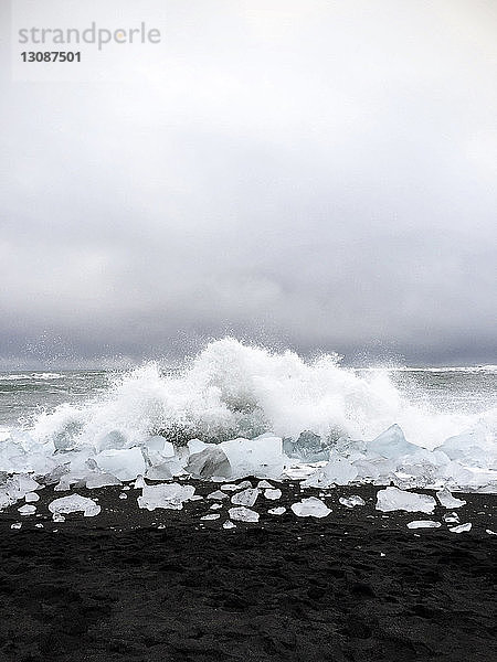Idyllischer Anblick von Wellen  die am Strand auf Gletschern gegen den Himmel plätschern