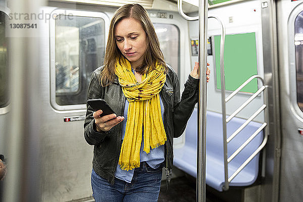 Frau benutzt Smartphone während einer Zugfahrt