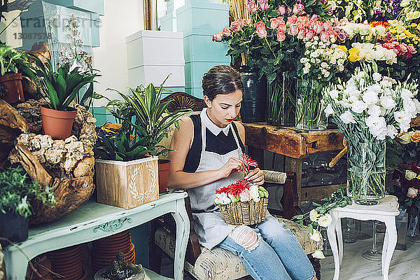 Florist arrangiert Blumen im Topf im Geschäft