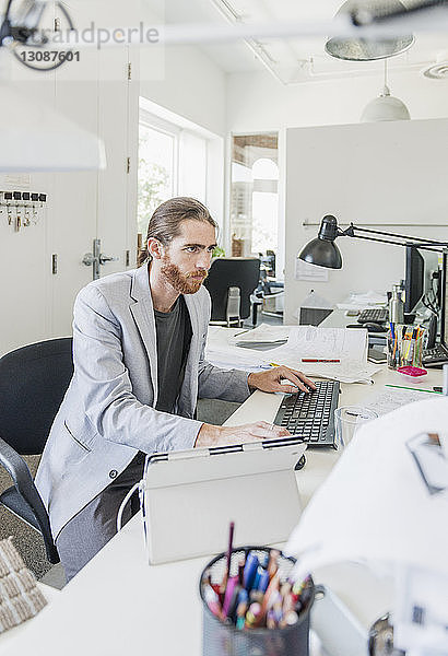 Geschäftsmann mit Computer im Kreativbüro