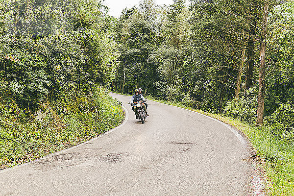 Ehepaar fährt Motorrad im Wald