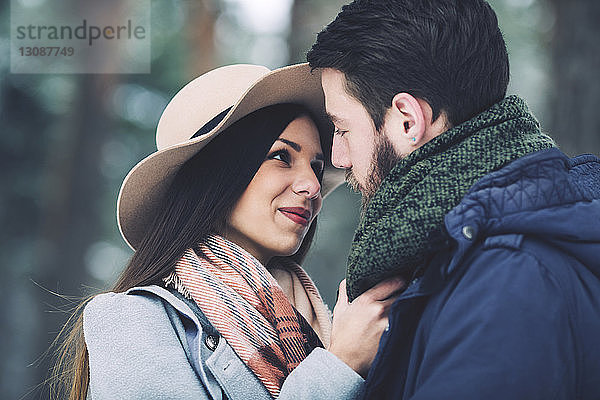 Nahaufnahme eines romantischen Paares  das sich im Winter im Wald betrachtet