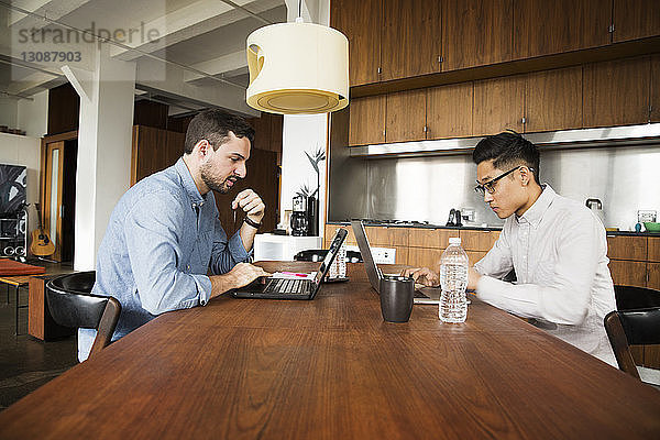 Geschäftspartner mit Laptop-Computer auf dem Tisch im Kreativbüro