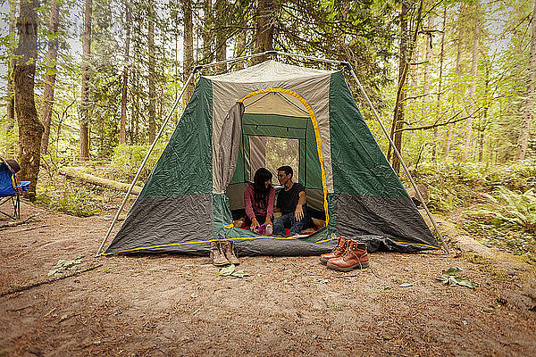 Ehepaar sitzt im Zelt auf dem Feld