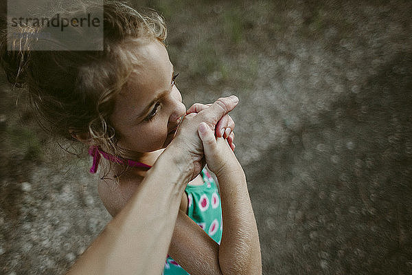 Ausgeschnittenes Bild einer Frau  die die Hand ihrer Tochter hält  während sie auf einem Fußweg steht