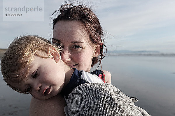 Porträt einer glücklichen Mutter mit Sohn am Sunset Beach