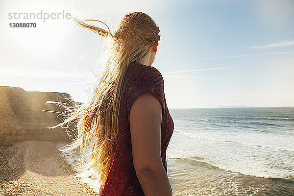 Seitenansicht einer Frau  die an einem sonnigen Tag am Strand steht