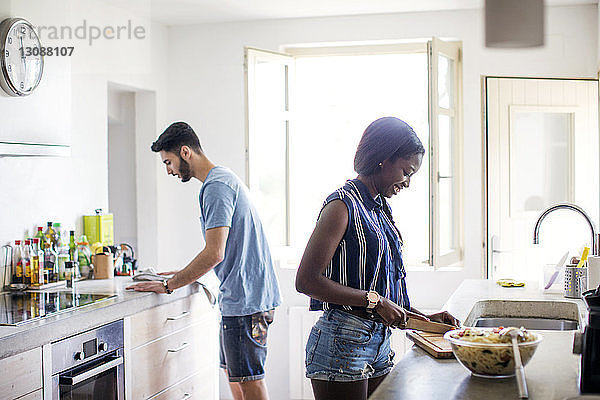 Seitenansicht eines in der Küche arbeitenden Paares