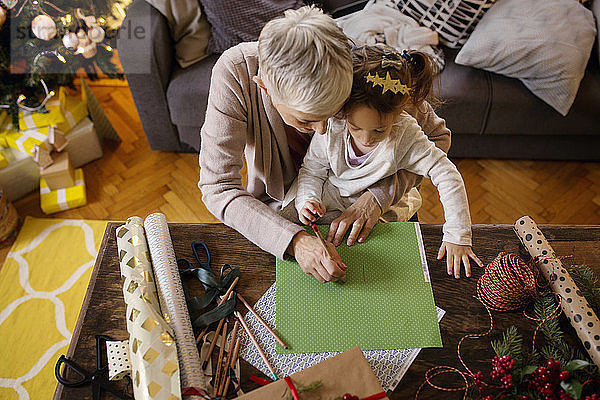 Draufsicht auf die Zeichnung von Großmutter und Enkelin auf Papier zu Hause
