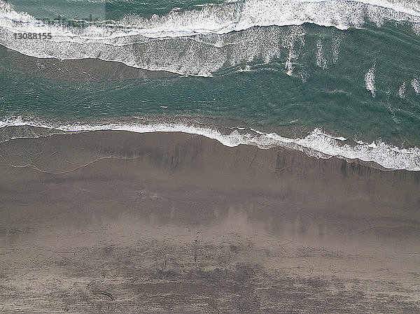 Landschaftliche Draufsicht auf die Wellen  die am Sunset Beach an Land fließen