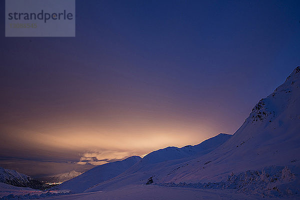 Idyllischer Blick auf schneebedeckte Berge vor klarem Himmel bei Sonnenaufgang