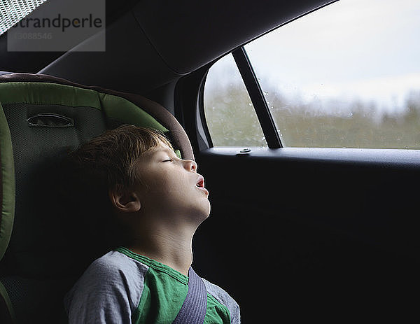 Junge schläft während der Fahrt im Auto